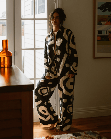 KENI Sleepwear Bright Eyes Linen Pants in a bedroom – Long shot displaying the elegant and relaxed style of our linen pants in a cozy setting