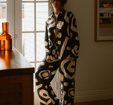 KENI Sleepwear Bright Eyes Linen Pants in a bedroom – Long shot displaying the elegant and relaxed style of our linen pants in a cozy setting